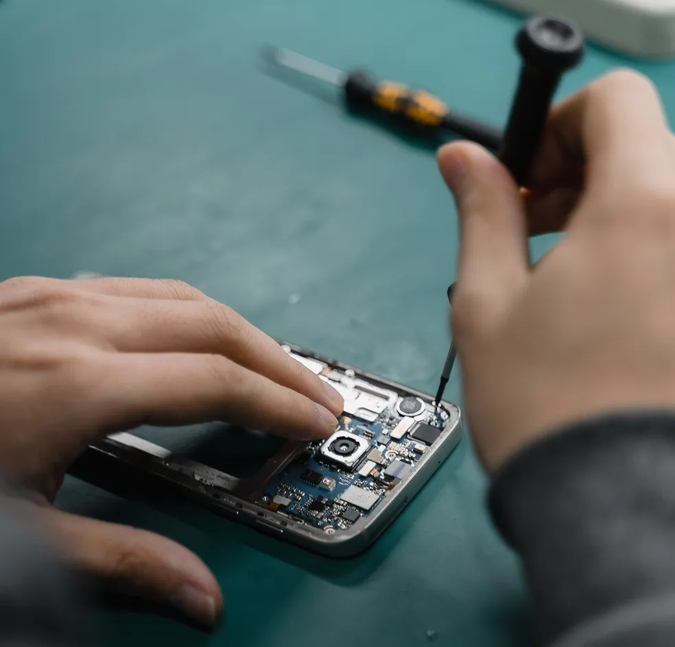 A person repairing a smartphone in a repair station